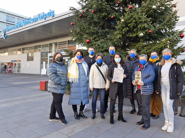 Die Freude über den Gewinn des „Corporate Health Awards 2021“ steht allen Beteiligten ins Gesicht geschrieben – daran ändern auch die obligatorisch zu tragenden Masken nichts. Foto: Stefan Straube / UKL