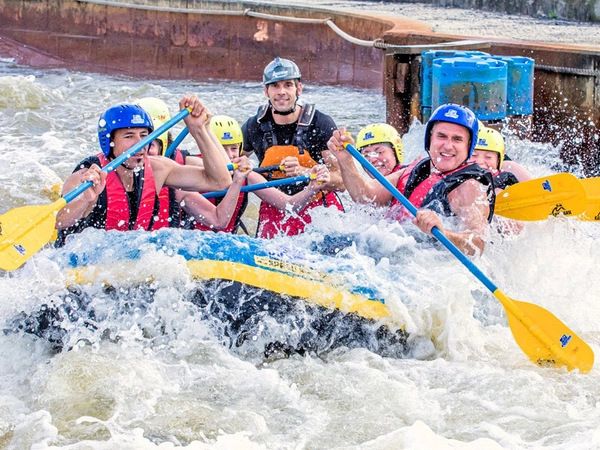 Der Raftguide (Bildmitte) steuert beim Wildwasser-Rafting das Schlauchboot mit den Gästen durch den Kanal, Foto: Kanupark Markkleeberg