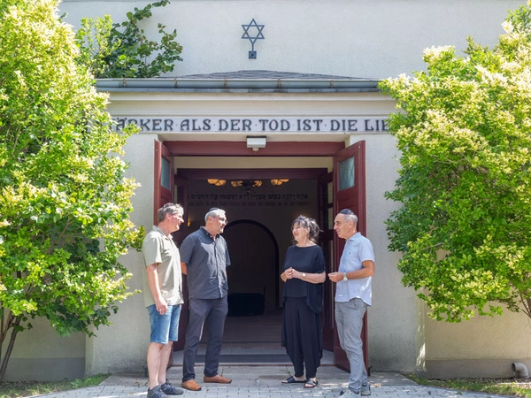 Historiker Steffen Held, HTWK-Architektur-Professor Ronald Scherzer-Heidenberger, Gemeindemitglied Eta Zachäus und Geotechnik-Professor Ralf Thiele am Eingang der Trauerhalle am Neuen Israelitischen Friedhof Leipzigs, Foto: Philipp Bamberg / HTWK Leipzig