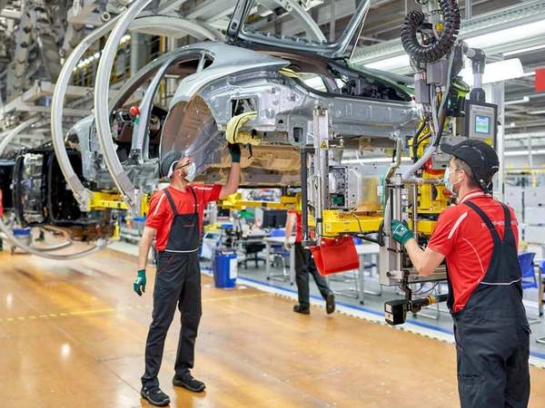 Mitarbeiter fertigen Verbrenner- und Hybridfahrzeuge auf einer Montagelinie, Foto: Porsche AG - Leipzig