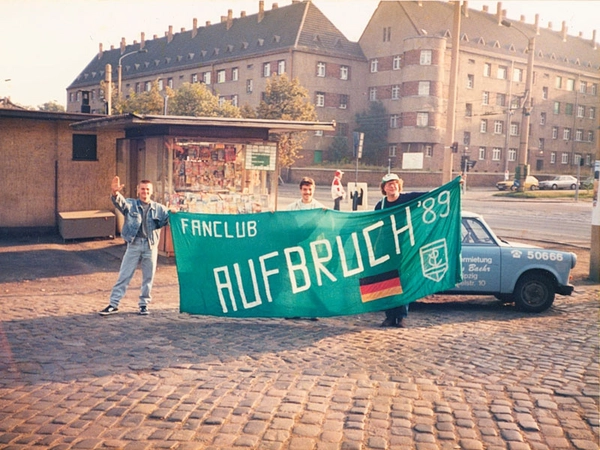 Vor einem Trabant und dem typischen Kratzputz der Fassaden steht die Fahne des „Fanclub Aufbruch 89“ als Symbol für den Umbruch, Neuanfang und die politische Wende. Foto: Thoralf