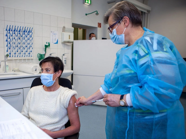 Diana Schweickert erhielt am 29. Dezember 2020 als erste Mitarbeiterin des UKL die Impfung von Dr. Melanie Weiss, Leiterin des Zentralen Bereichs Arbeitsmedizin und Arbeitssicherheit am UKL. Foto: Hagen Deichsel / UKL