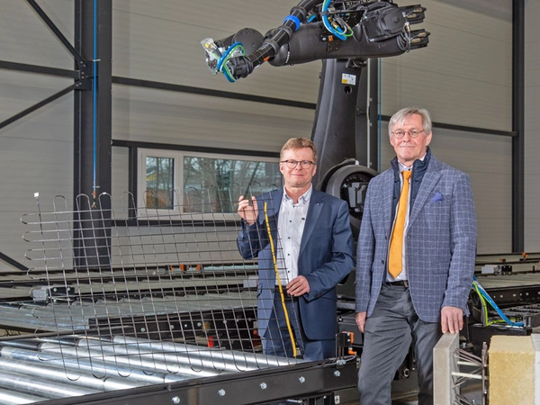 Prof. Tilo Heimbold und Prof. Klaus Holschemacher mit einem Carbonbetongelege mit integriertem AS-Interface-Kabel im Carbonbetontechnikum der HTWK Leipzig, Foto: Maximilian Johnson / HTWK Leipzig