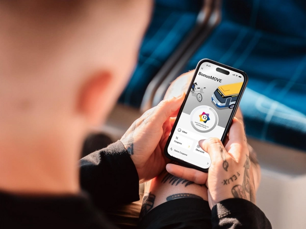 Schulterblick: Ein Kunde nutzt BonusMove auf seinem Smartphone, Foto: Leipziger Gruppe