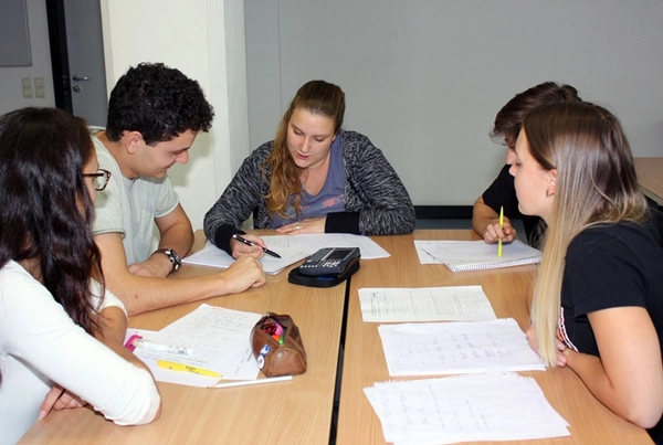 Tutorin Michelle Uth (Mitte) unterstützt Erstsemester des Wirtschaftsingenieurwesens Bau in der Gruppenarbeit zum Vorkurs Mathematische Grundlagen bei der Lösung ihrer Aufgaben. 