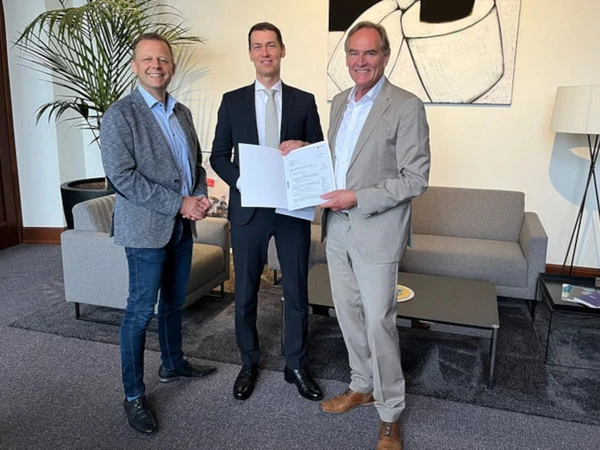 Finanzbürgermeister Torsten Bonew (links) und Oberbürgermeister Burkhard Jung erhalten den Genehmigungsbescheid von Béla Bélafi (Mitte), Präsident der Landesdirektion Sachsen. Foto: Stadt Leipzig