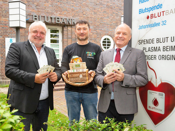Prof. Jörg Junhold und Prof. Reinhard Henschler überreichen Stephan Deckert vom Purzelbaum Leipzig e.V. 140 Kinder-Eintrittskarten für den Zoo. Foto: Stefan Straube / UKL